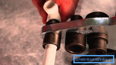 Amateur photo demonstrating the process of soldering pipes using special tools