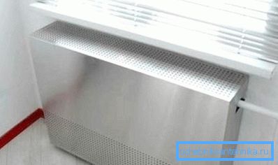 Metal screen on a radiator with holes for free air circulation Metal screen on a radiator with holes for free air circulation