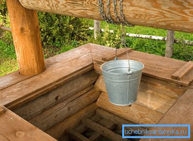 In the photo - a well made of wood In the photo - a well made of wood