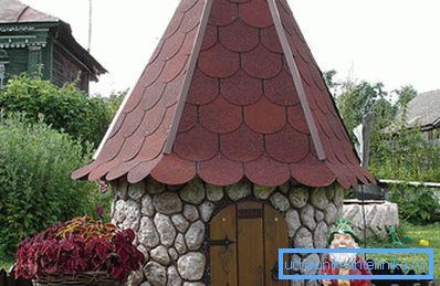 In the photo is a stone house for a well. In the photo is a stone house for a well.