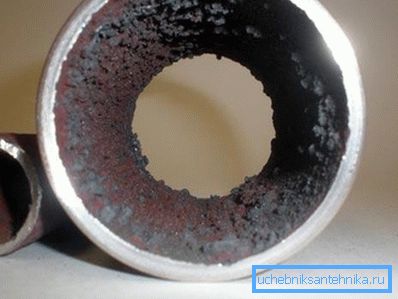The photo shows limescale and corrosion on the inner surface of the pipe. The photo shows limescale and corrosion on the inner surface of the pipe.