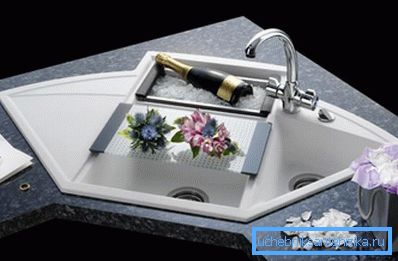 On the photo is a sink with a cutting board. On the photo is a sink with a cutting board.