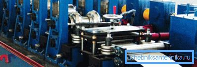 In the photo in the machine is fed steel tape for the production of pipes