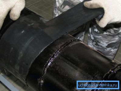 Application of polymer roll waterproofing on the pipeline section. Application of polymer roll waterproofing on the pipeline section.