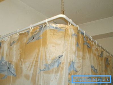 Corner shower curtain on a hanging rod.